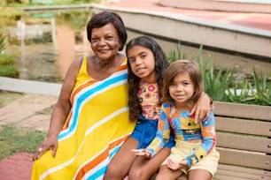 a woman and two children sitting on a bench