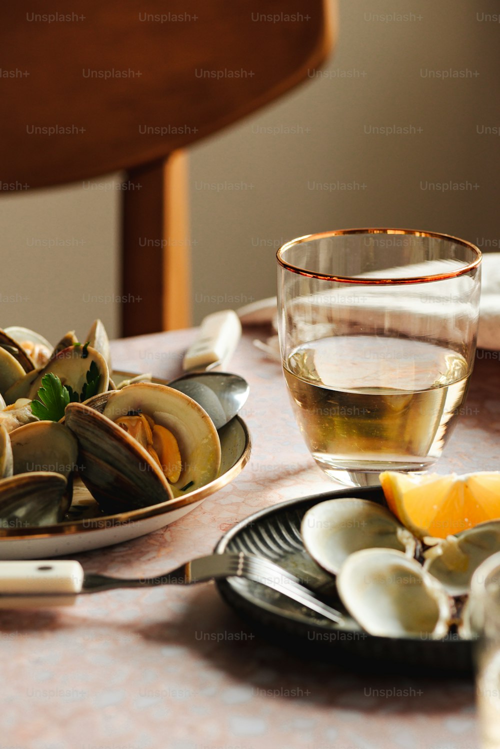 a plate of mussels and a glass of wine on a table