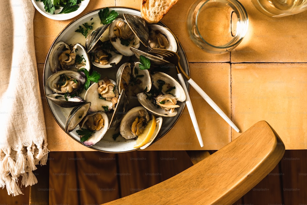 a plate of clams and bread on a table