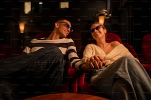 a man and a woman sitting on a red couch