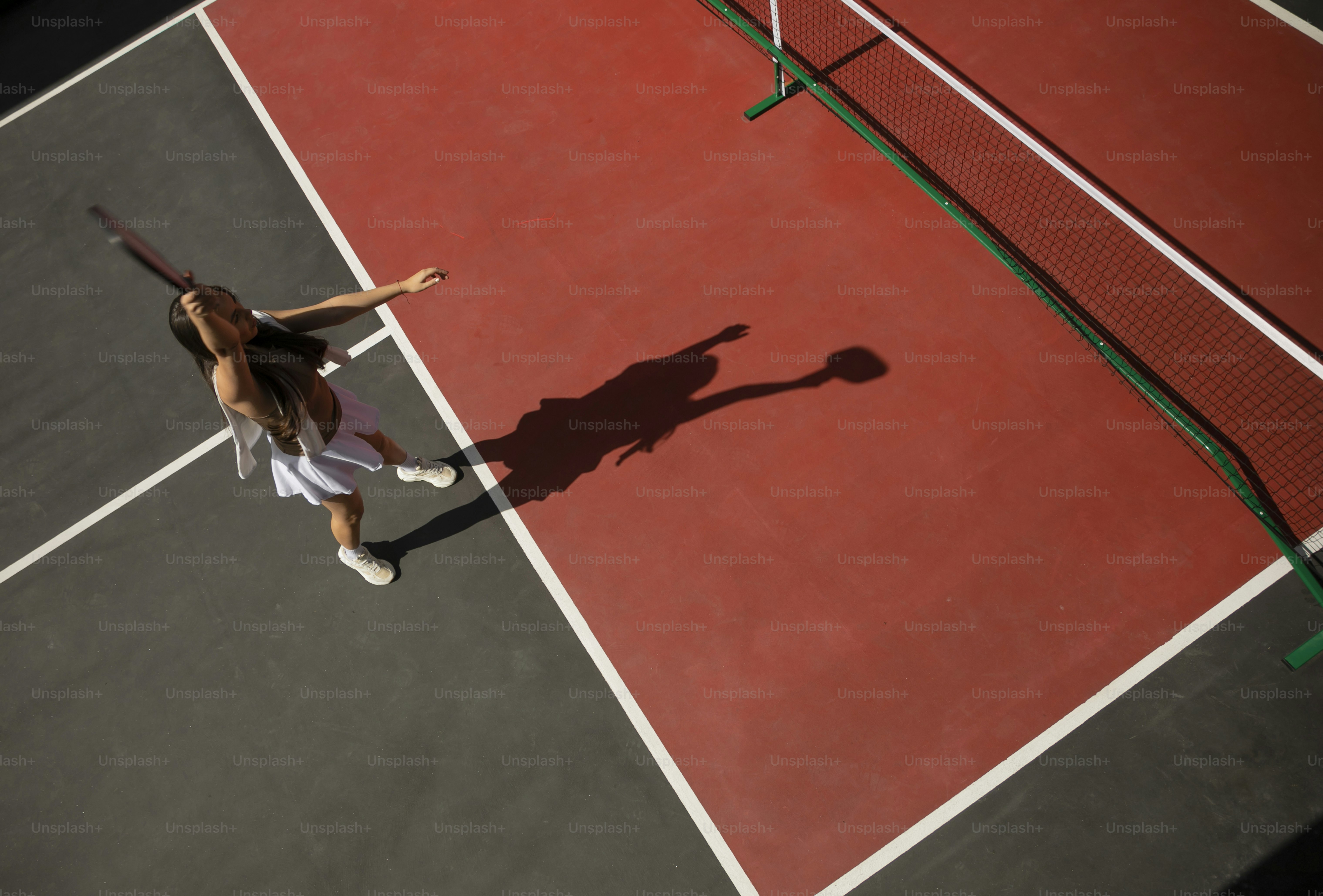 una donna in piedi su un campo da tennis con in mano una racchetta