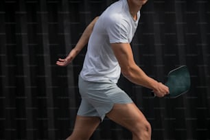 ein Mann, der einen Tennisschläger auf einem Tennisplatz hält