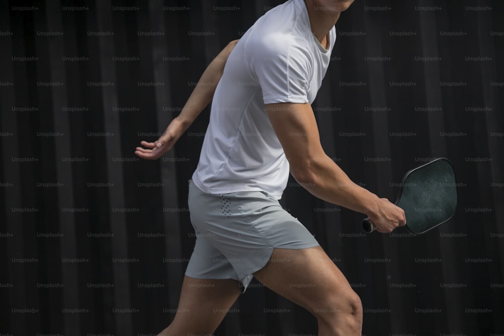 テニスコートの上でテニスラケットを持つ男性