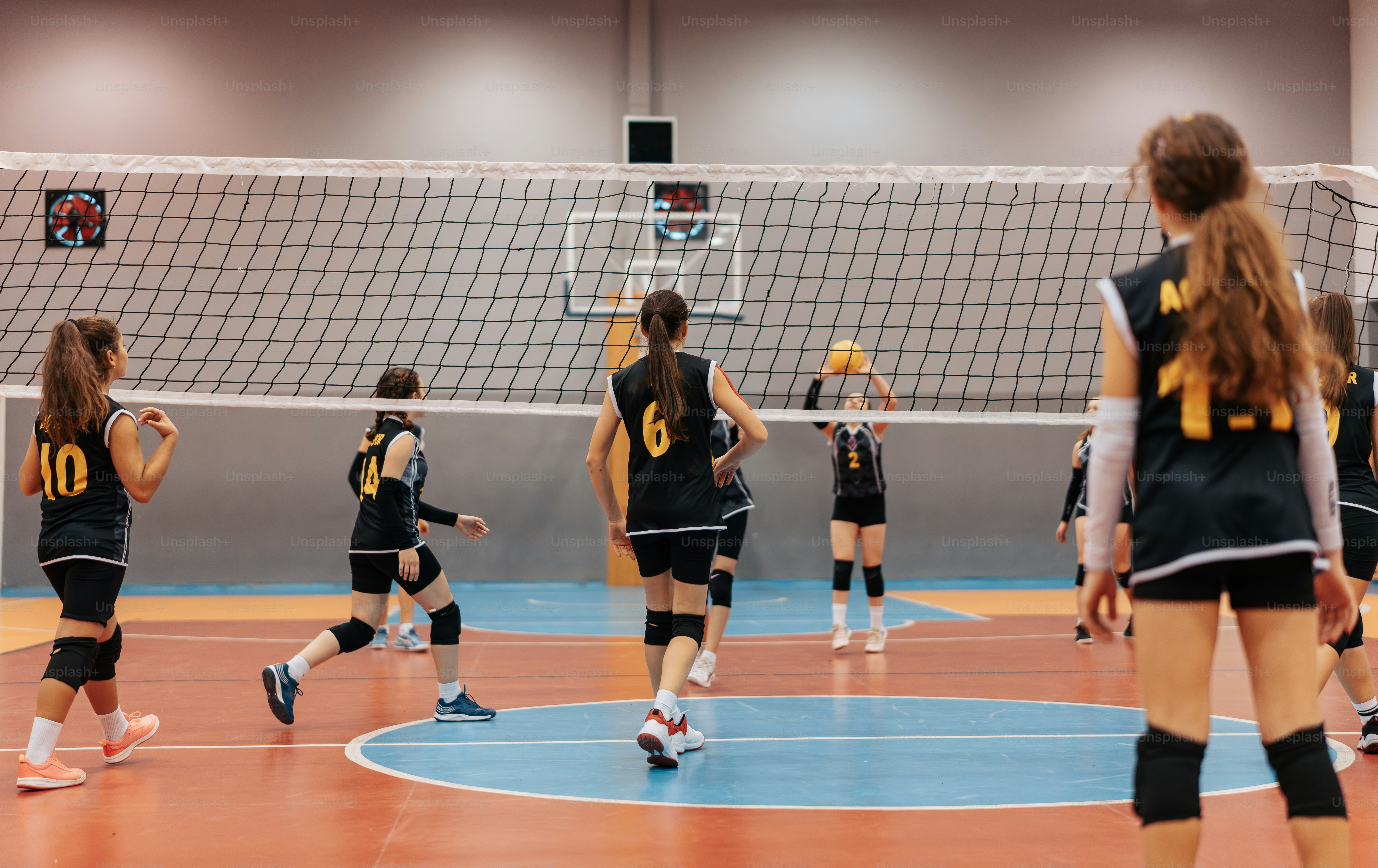 a group of girls playing a game of volleyball