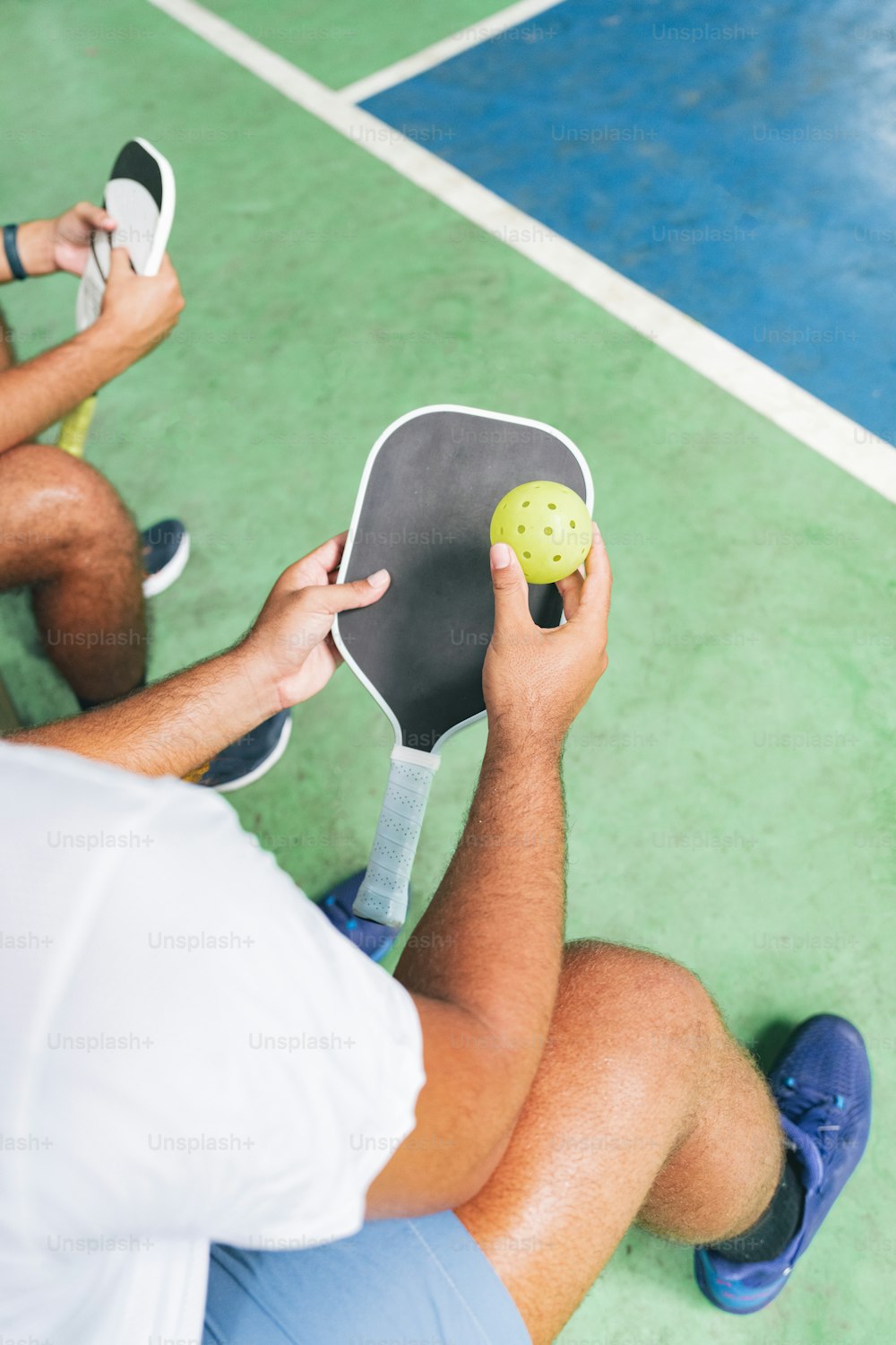 un homme tenant une raquette de tennis et une balle de tennis