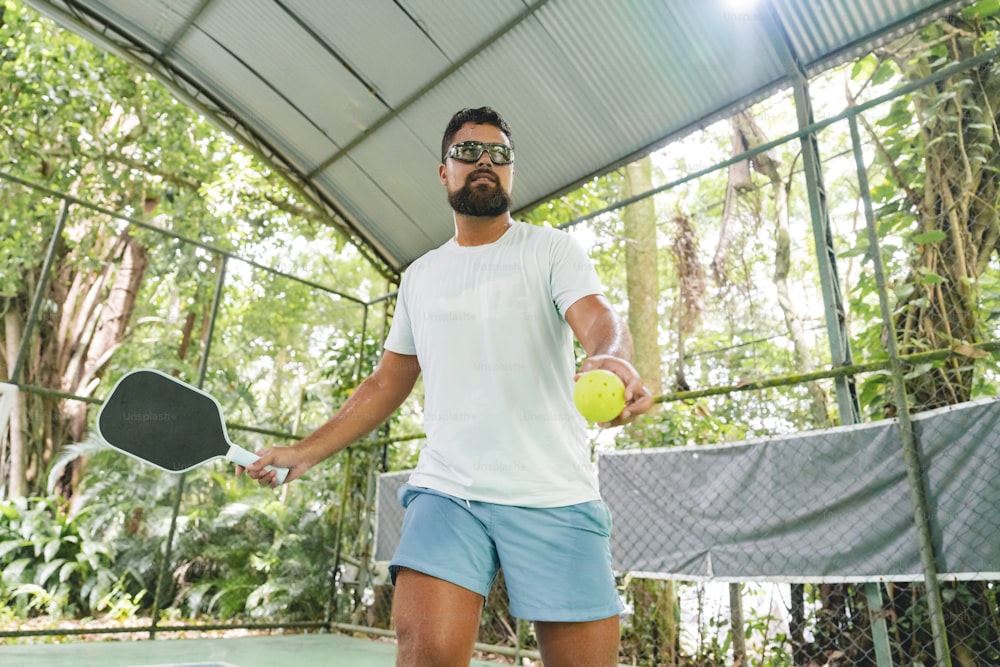 a man holding a tennis racquet and a tennis ball