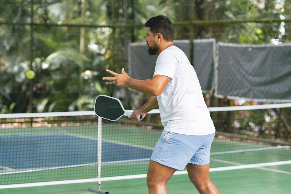 a man holding a tennis racquet on top of a tennis court