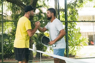 un couple d’hommes debout sur un court de tennis