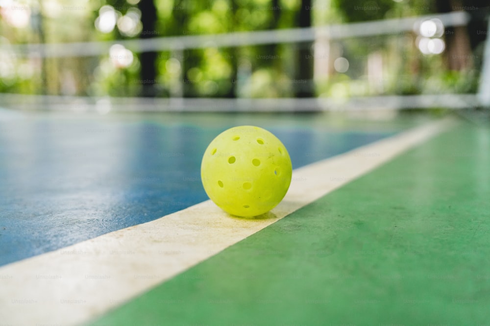 a tennis ball sitting on the edge of a court
