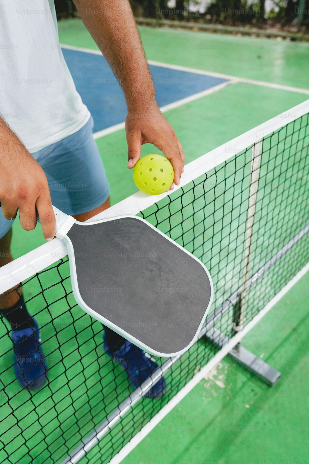 a man holding a tennis racquet and a ping pong paddle