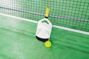 a tennis racket and ball on a court