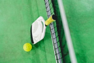 a tennis racket and ball on a green court