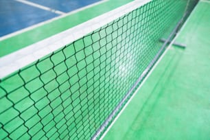 Un primer plano de una red de tenis en una cancha de tenis
