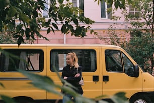 Une femme debout devant une camionnette jaune