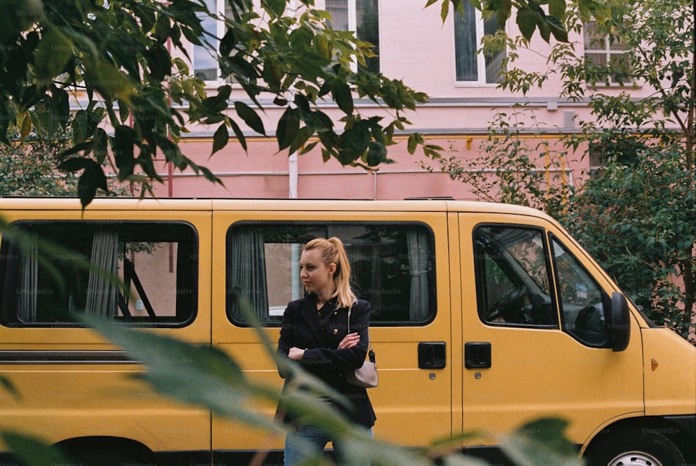 uma mulher em frente a uma van amarela