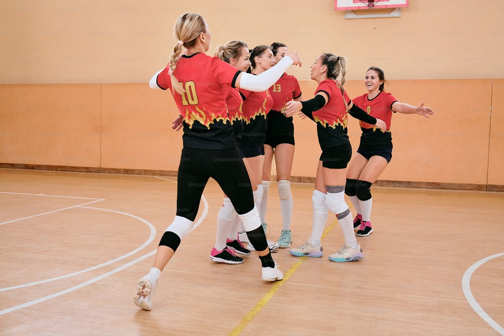 a group of young women playing a game of volleyball