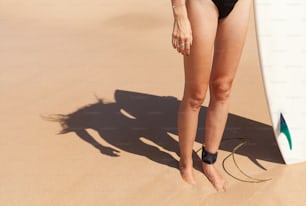 a woman in a bathing suit holding a surfboard