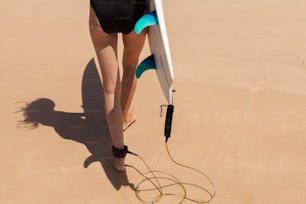 a woman in a bathing suit carrying a surfboard