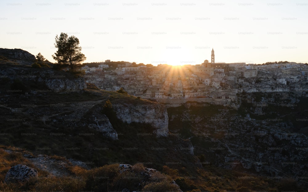 the sun is setting over a rocky cliff