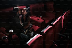 um casal de pessoas que estão sentadas em um teatro