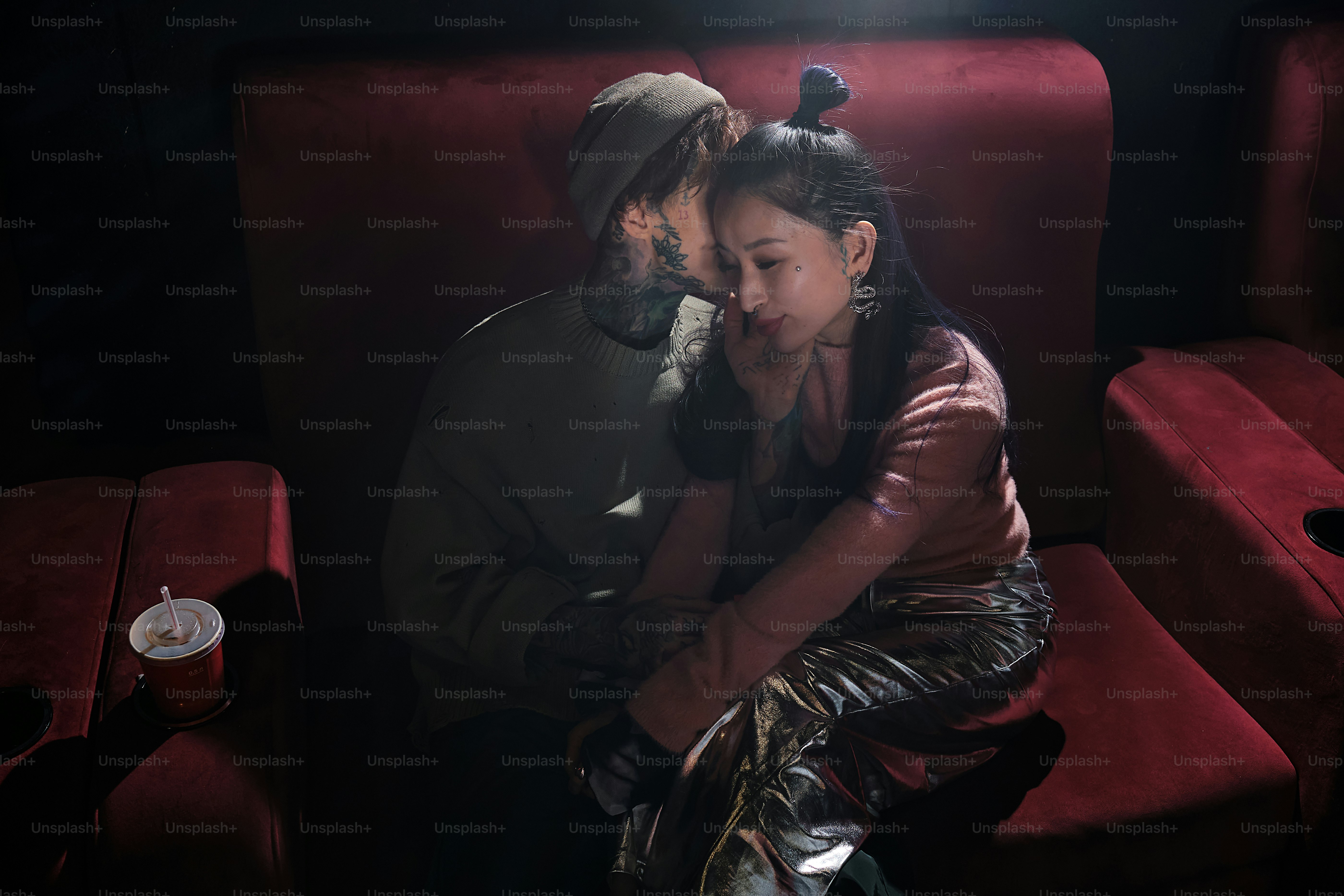 a man and a woman sitting on a red couch