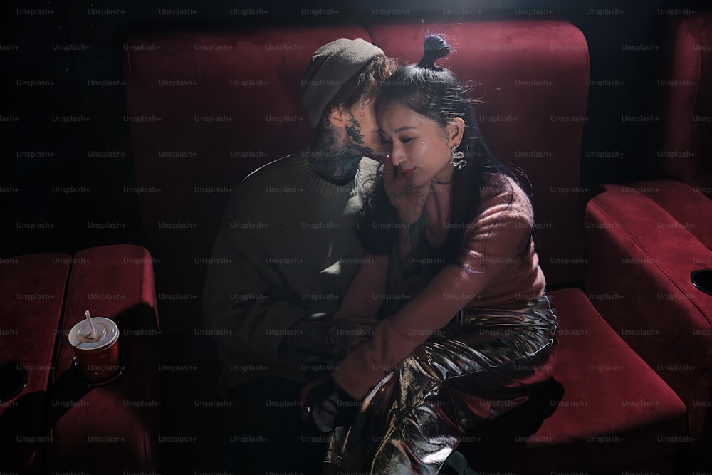 a man and a woman sitting on a red couch