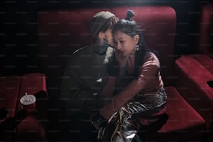 a man and a woman sitting on a red couch