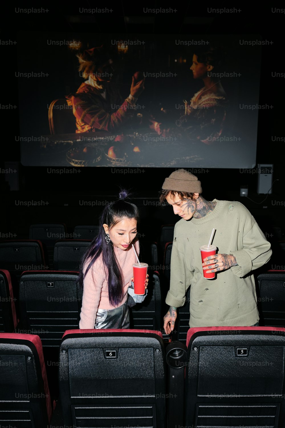 a man standing next to a woman holding a cup