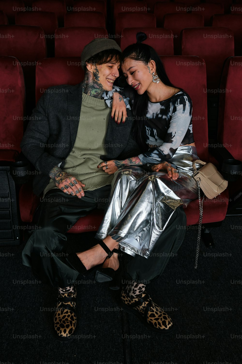 a man and a woman sitting on a red chair