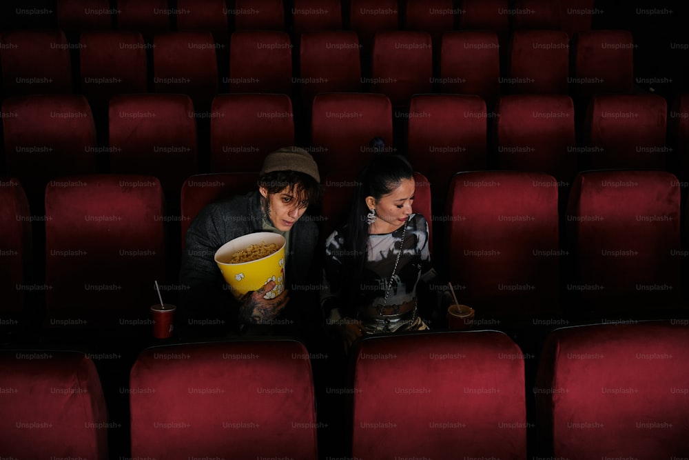 um homem e uma mulher sentados em uma sala de cinema