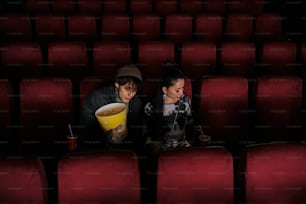 a man and a woman sitting in a movie theater