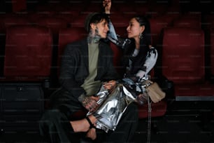 uma mulher sentada ao lado de um homem em um teatro