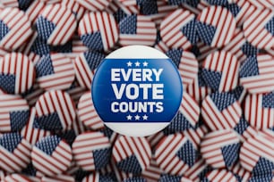 a button that says every vote counts surrounded by american flags