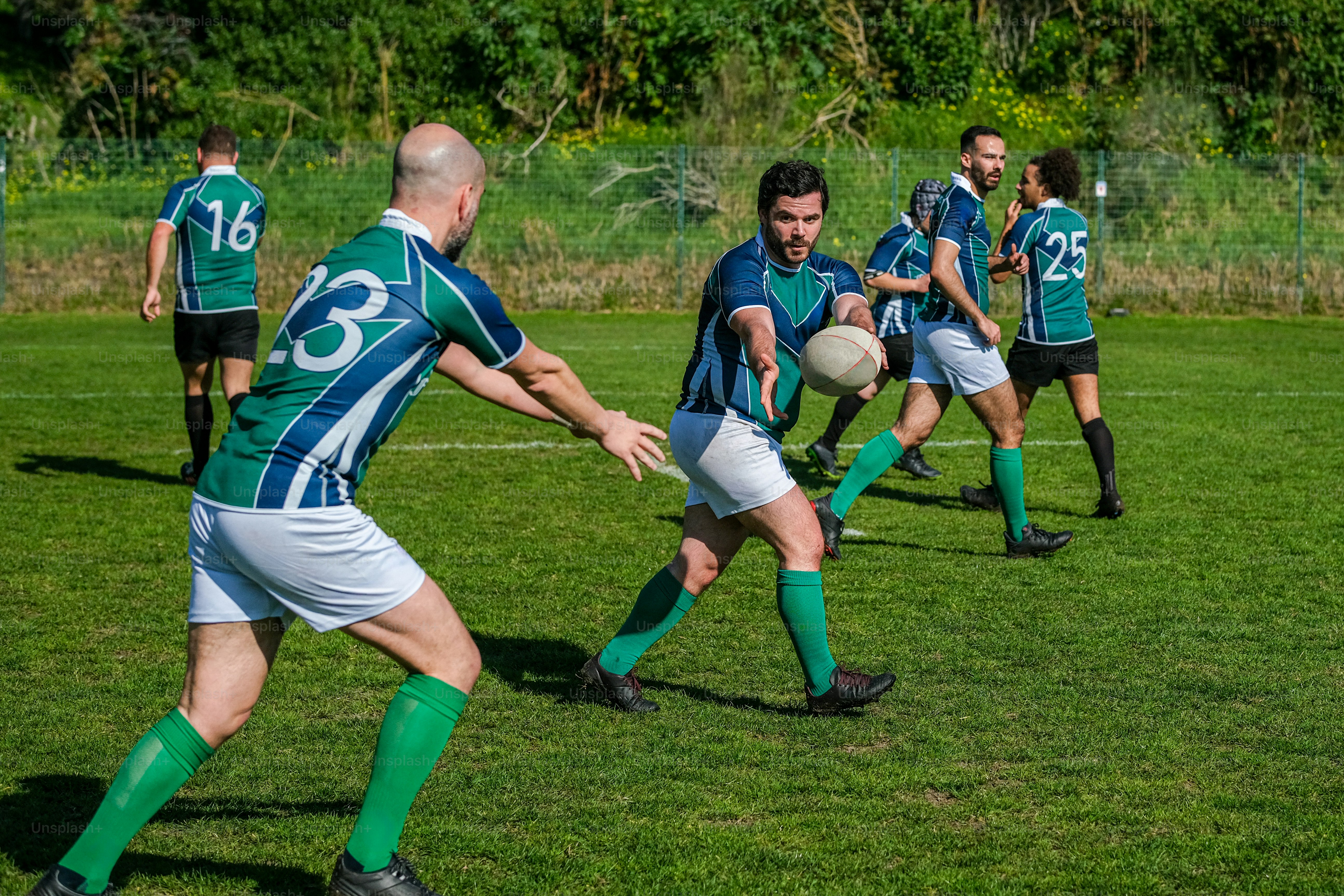 A group of people playing a game of frisbee photo – Rugby ball Image on ...