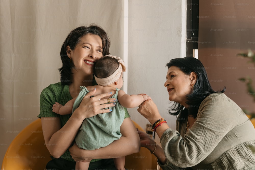 a woman is holding a baby and smiling