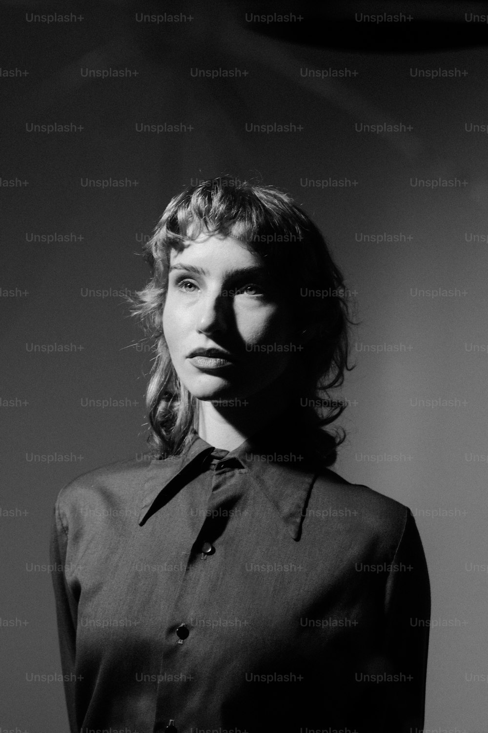 a black and white photo of a woman wearing a shirt and tie