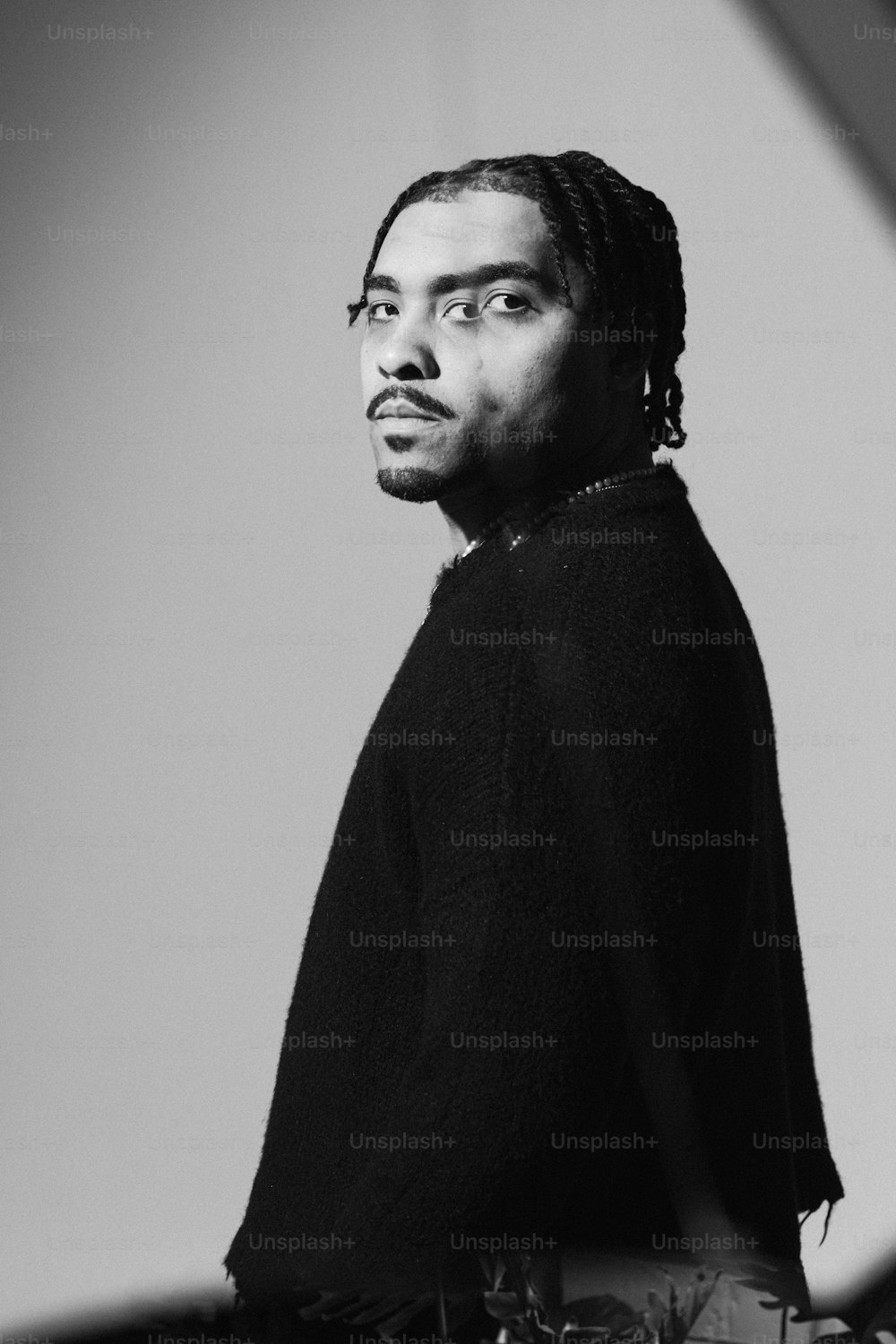 a black and white photo of a man with dreadlocks