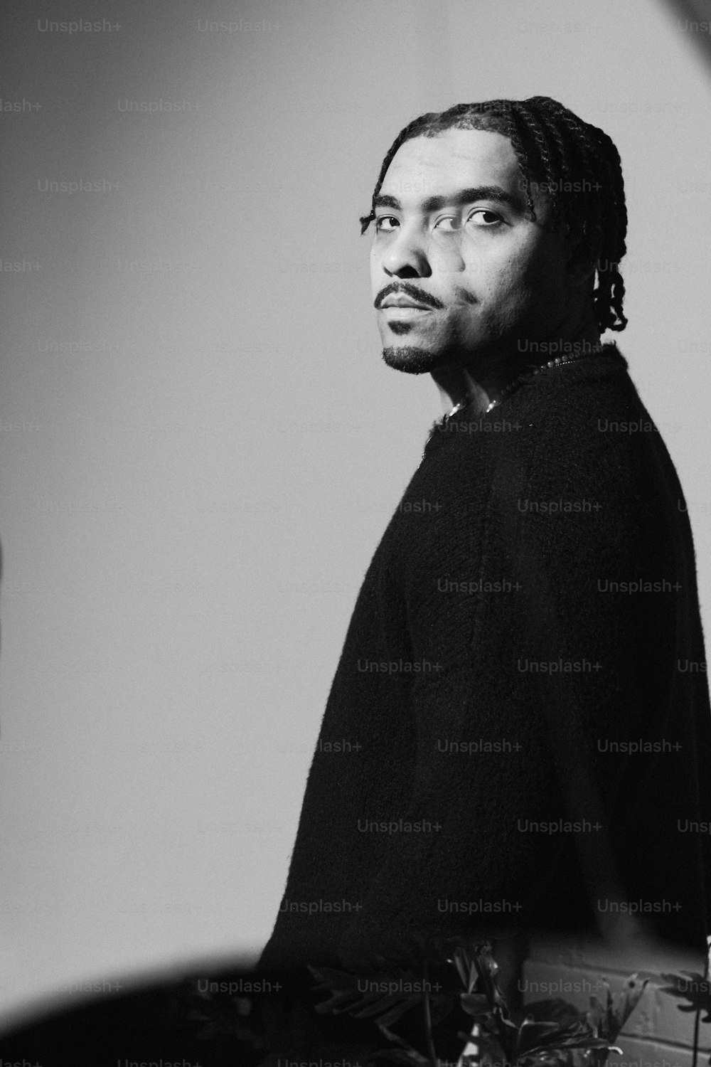 a black and white photo of a man with dreadlocks