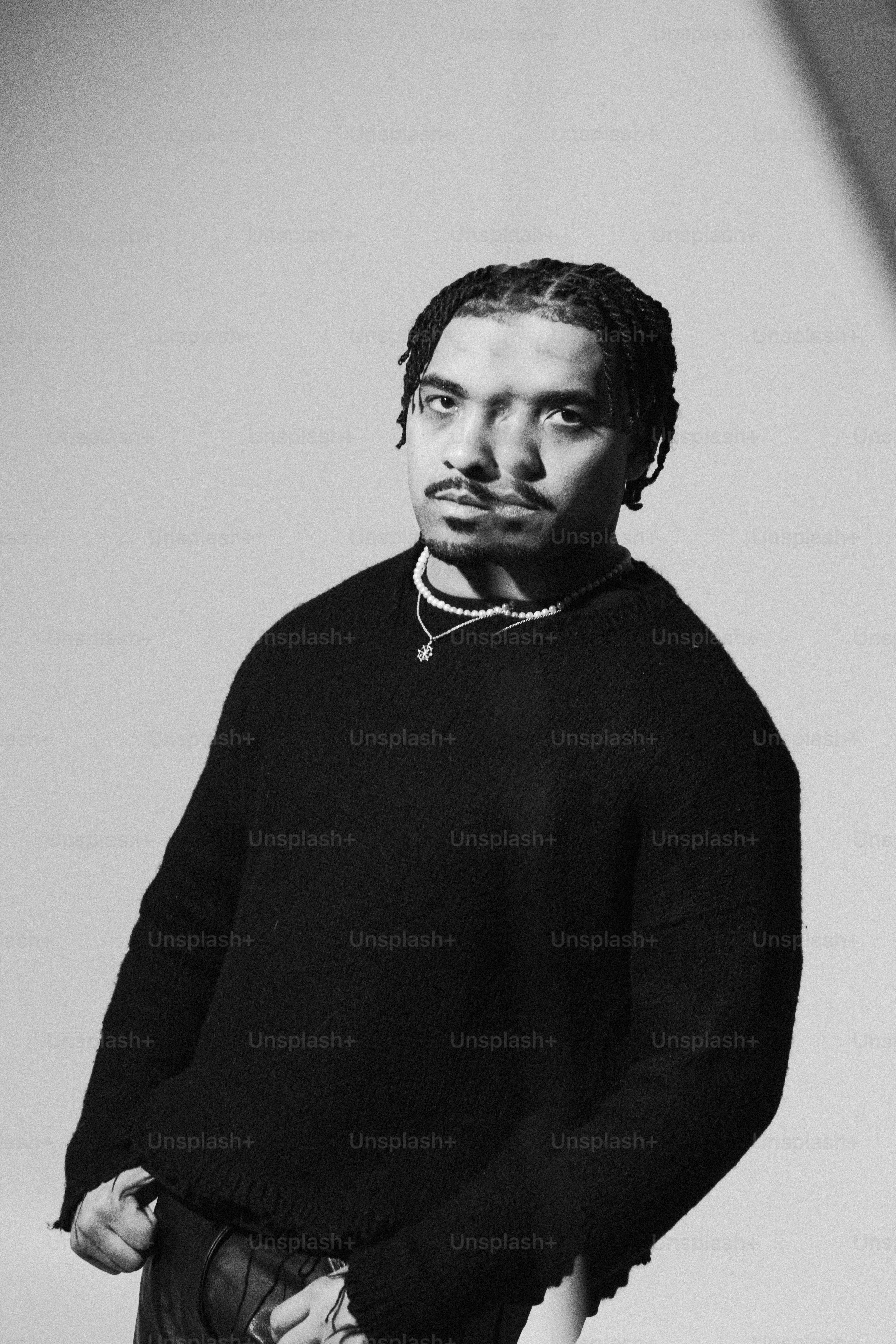 ein Mann mit Dreadlocks, der einen schwarzen Pullover trägt