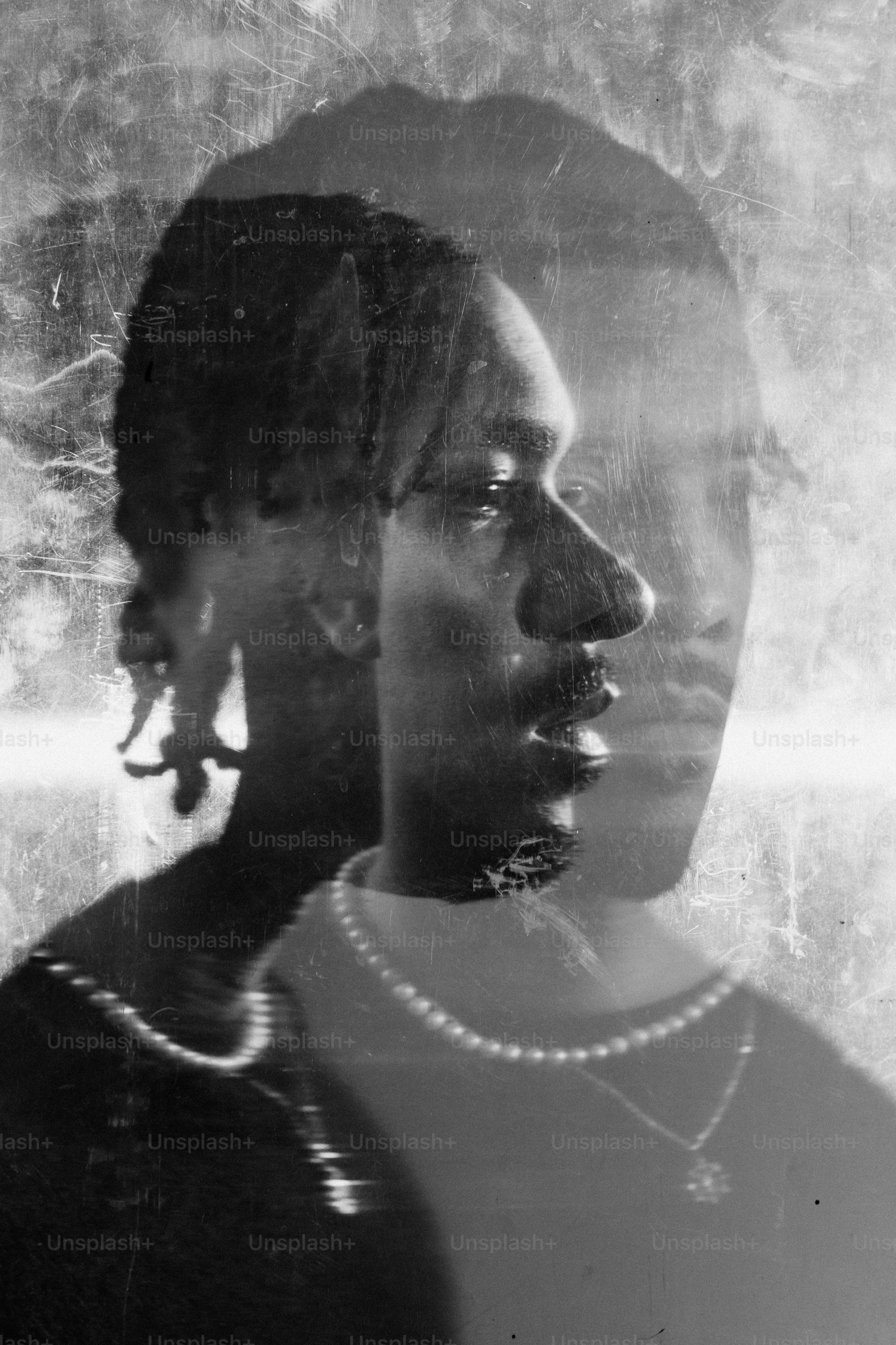 a black and white photo of a woman with a pearl necklace
