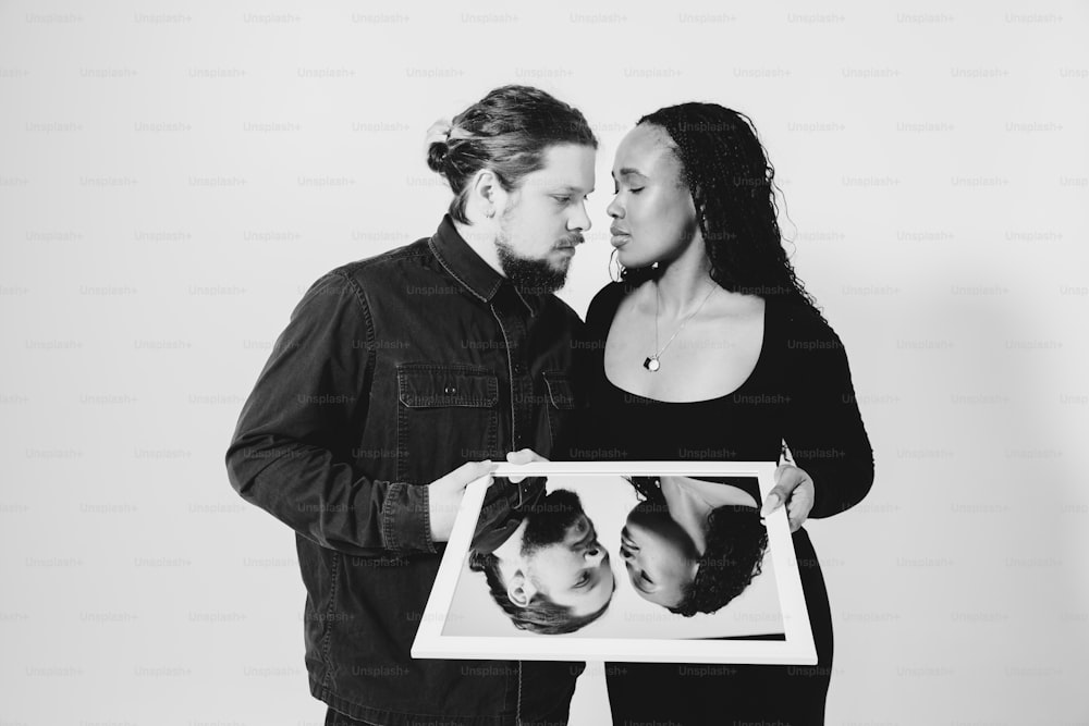 a man and woman holding a picture of a baby