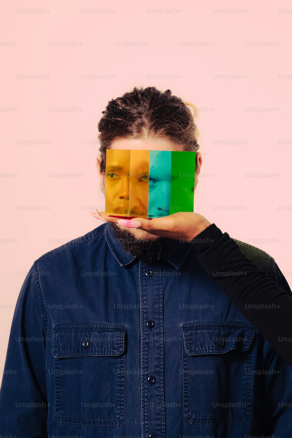 a man holding a piece of paper over his face