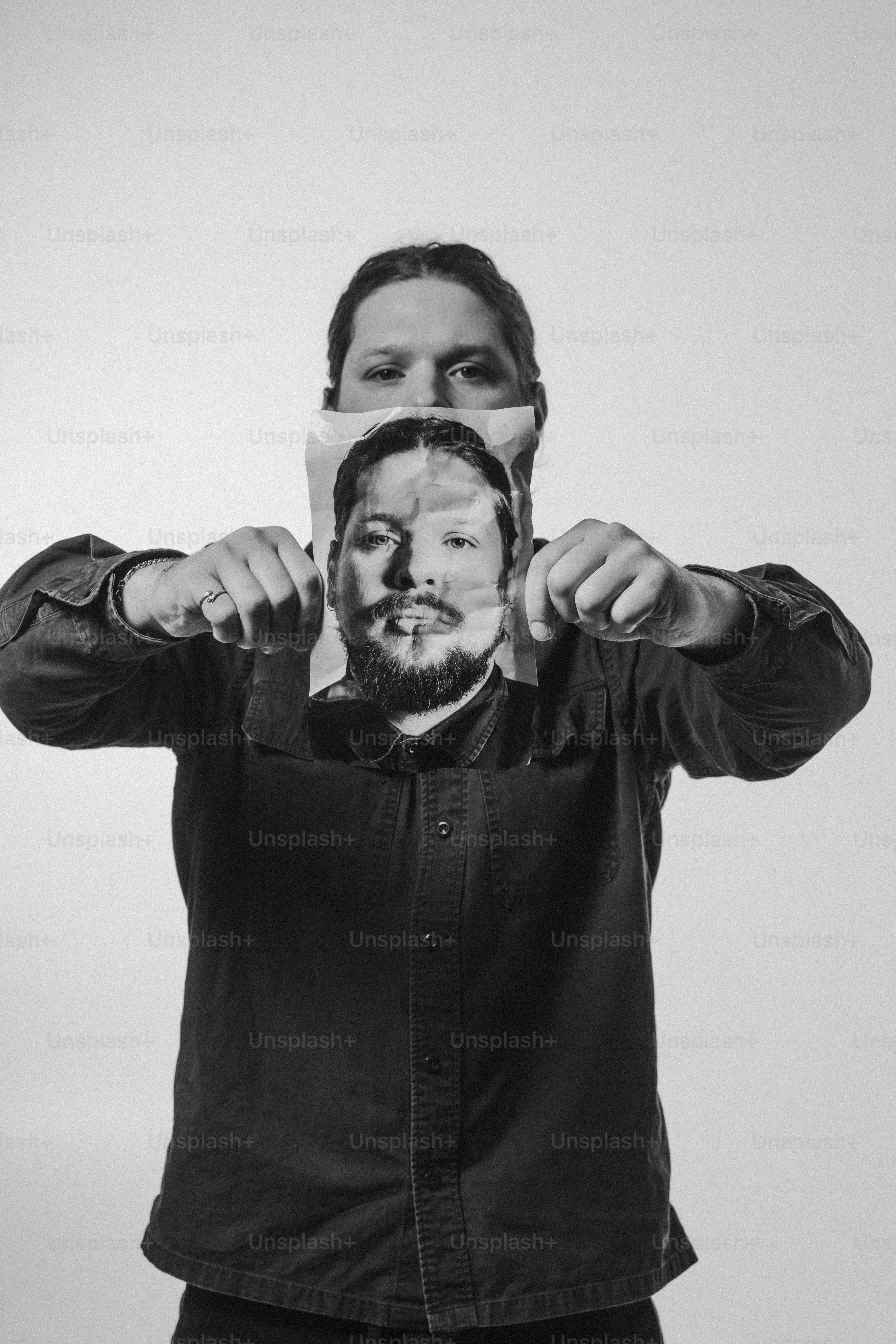 a man holding a piece of paper over his face