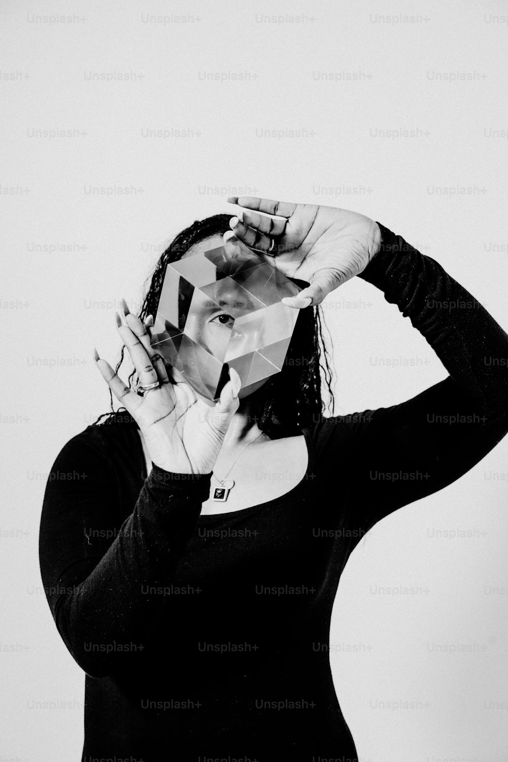 a woman in a black shirt is holding her hands up to her face