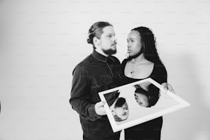 a man and woman holding a picture of themselves