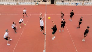 a group of people standing on a tennis court holding racquets