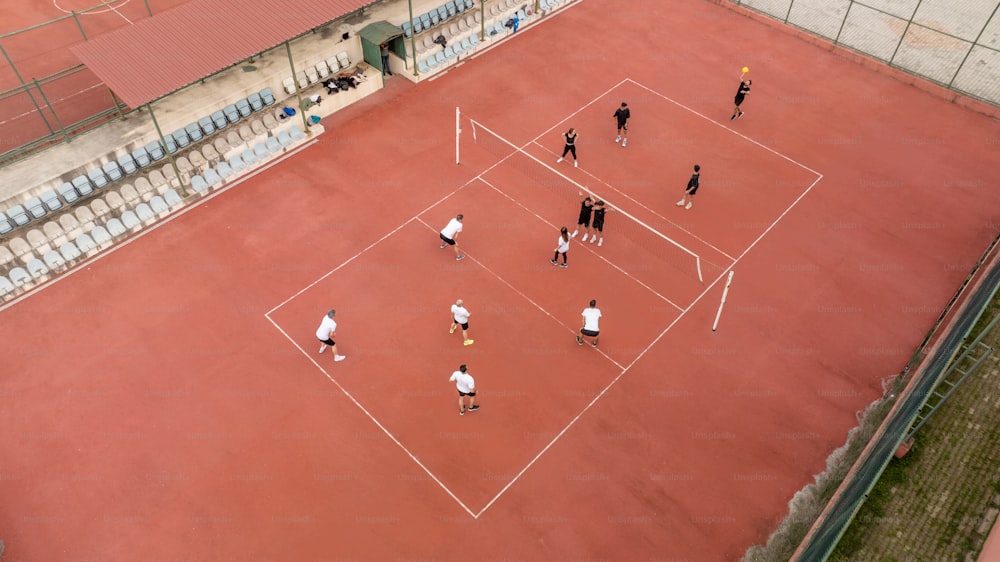 Un grupo de personas de pie encima de una cancha de tenis