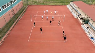 a group of people standing on top of a tennis court