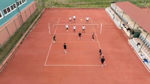 Un grupo de personas de pie encima de una cancha de tenis