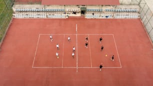 a group of people standing on top of a tennis court